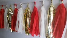 red, white and gold tassels hanging on a wall