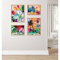 three colorful paintings hang on the wall next to a white couch