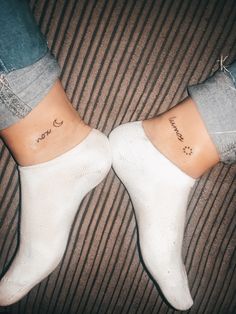 two people with matching tattoos on their legs sitting next to each other, both wearing white socks