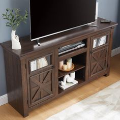 a flat screen tv sitting on top of a wooden entertainment center