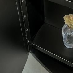 there is a small vase with flowers in it on the shelf next to the microwave