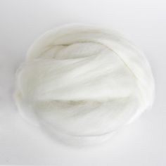 a ball of white wool sitting on top of a table