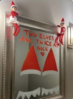 two elfs are sitting on top of a mirror with the words two elves are twice as nice