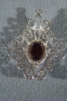 I am offering you this gorgeous vintage designer signed Sarah Coventry silver tone extra large very fancy scrolled crest like shape pendant charm with a huge oval cut African amethyst colored rhinestone set in the center. It measures app. 3 inches, by 2 1/4 inch. What a fantastic gift this would make ! This is a must have for the jewelry collector. Buyer pays all shipping and handling fees, we will always combine shipping. Item ID:0009081 Silver Jewelry With Large Pendant For Evening, Silver Oval Pendant Costume Jewelry, Silver Oval Pendant Necklace For Party, Ornate Silver Oval Pendant Jewelry, Silver Oval Pendant Jewelry For Party, Vintage Sterling Silver Rings, Amethyst Color, Purple Rhinestone, Sarah Coventry