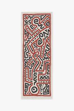 a red and black rug with an abstract design on the bottom, in front of a white background