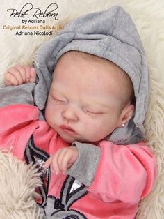 a newborn baby wearing a gray and pink outfit