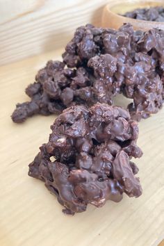 chocolate clusters on a wooden cutting board next to a spoon