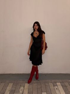 Red boots styled with a black crochet dress and red slouchy bag Red Calf Boots Outfit, Winter Heels Outfit Dress, Black Mini Skirt Black Boots, Fall Skirt And Dress Outfits, Dress With Patterned Tights, Crochet Dress With Boots, Black Dress Red Cowgirl Boots, Black Skirt And Black Boots Outfit, Red Boots Aesthetic Outfit