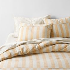 a bed with yellow and white striped sheets