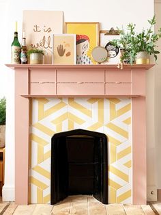 a pink fireplace with yellow and white tiles on the mantel above it is decorated with greenery