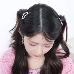 a girl with long black hair is wearing some kind of headband and has two pearls in her hair