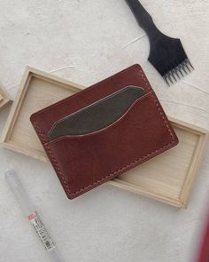 A beautiful classic card wallet, hand stitched with whiskey thread and handmade with Medium Brown Buttero Leather from Conceria Walpier tannery in Italy and accented with a green card slot. This timeless wallet will last a lifetime and age beautifully over time. Handstitched at 4mm spacing using 0.45mm thread . Thread choices : Whiskey (Shown Pic 1-3), Coffee (pictures 5-7) , Cream, Olive, Navy, Grey This wallet can hold 5-6 cards and features a small sleeve to carry cash.  Measures 4.25" x 3" A Handmade Wallet, Wallet Minimalist, Coffee Pictures, Him Gifts, For Him Gifts, Handmade Wallets, Leather Card Wallet, Classic Card, Handmade Leather Wallet