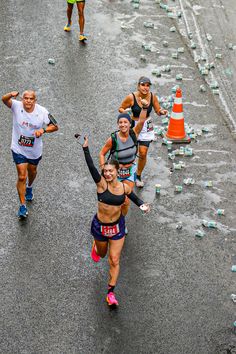 a group of people running down a street next to traffic cones and cones on the ground