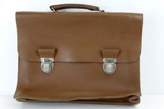 a brown leather briefcase sitting on top of a white table