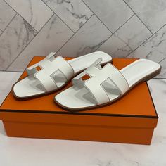 Hermes Oran Sandal Size 40 New With Box And Dust Bags Color Blanc (White) Come With Dust Bag And Box. Classic White Sandals For Vacation, White Hermes Sandals, Hermes Sandals, Hermes Oran Sandals, White Slippers, Hermes Orange, Rubber Sandals, Hermes Oran, Hermes Shoes