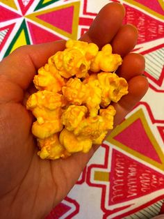 someone is holding some yellow popcorn in their hand