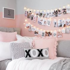 a bedroom decorated in pink, grey and white with pictures on the wall above the bed