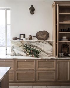 a kitchen with marble counter tops and wooden cabinets