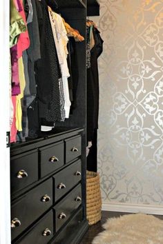 an organized closet with clothes hanging on hangers and a rug in front of it