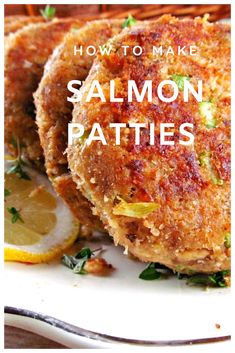 salmon patties on a white plate with lemon wedges