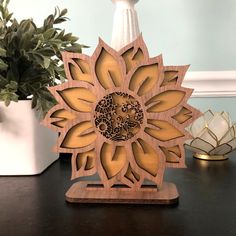 a wooden sunflower on a table next to a potted plant