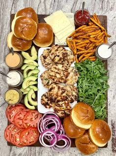 an assortment of food including burgers, french fries and tomatoes