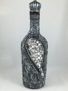 a bottle that has some kind of design on it's side and is decorated with pearls