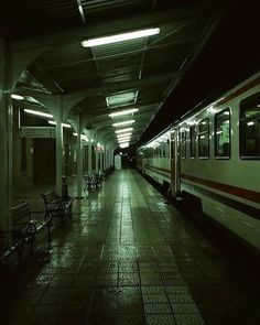 a subway station with benches and lights at night