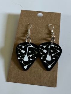 black and white guitar pick shaped earrings on a brown card with silver earwires