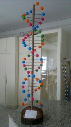 a multicolored tree is on display in the middle of a room with white cabinets