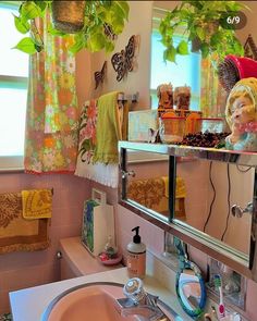 a bathroom with a sink, mirror and plants hanging from the ceiling over it's bathtub