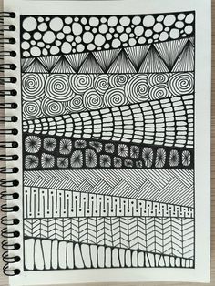 a spiral notebook with black and white designs on it