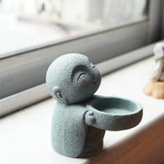 there is a small stone bear sitting on the window sill