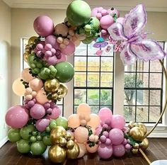 the balloon arch is decorated with balloons and flowers