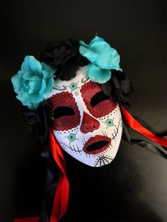 Crafted with intricate details, this masquerade mask embodies the spirit of Dia de los Muertos. The blue flowers add a burst of color and symbolize the lively nature of the celebration. Whether you're celebrating Dia de los Muertos, attending a themed event, or simply embracing the beauty of this cultural celebration, our sugar skull mask is the perfect choice!


Age Group/Gender - Adult/Women

Size/Type - One size fits all adults

Mask Color - White/red

Flower Color - Black and blue
Special Fe