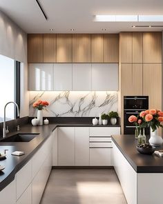 a modern kitchen with white cabinets and black counter tops, flowers in vases on the island