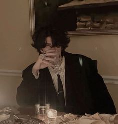 a woman sitting at a table with a glass in her hand