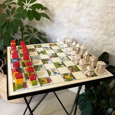 a board game set up on a table next to a potted plant and basket