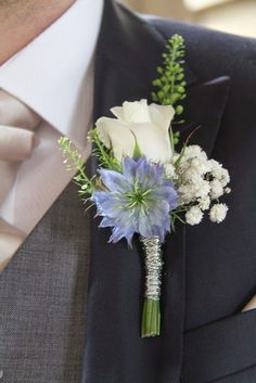 a man wearing a suit and tie with a boutonniere on his lapel