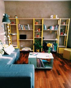 a living room filled with furniture and bookshelves next to a wooden flooring