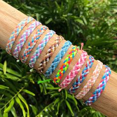 a close up of a person's arm with different colored bracelets on it