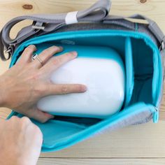 a person holding onto a blue and white bag with their hand on the back of it