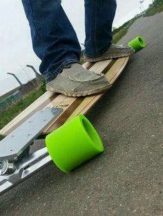 a person standing on top of a skateboard next to a green cup and an orange tube