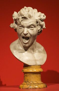 a marble bust of a man with his mouth open and tongue out in front of a red background