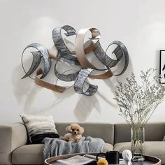 a living room filled with furniture and a large metal sculpture on the wall above it