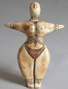 a ceramic figurine is standing on a gray surface