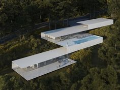 an aerial view of two modern houses in the woods with swimming pool and lounge chairs