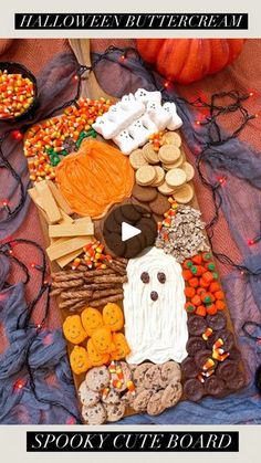 a decorated halloween board with candy, cookies and candies in the shape of a ghost