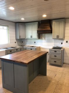 a kitchen with an island in the middle of it and cabinets on both sides,