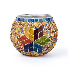 a colorful mosaic vase sitting on top of a white table